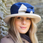 woman wearing navy rain hat with cream bow and under brim